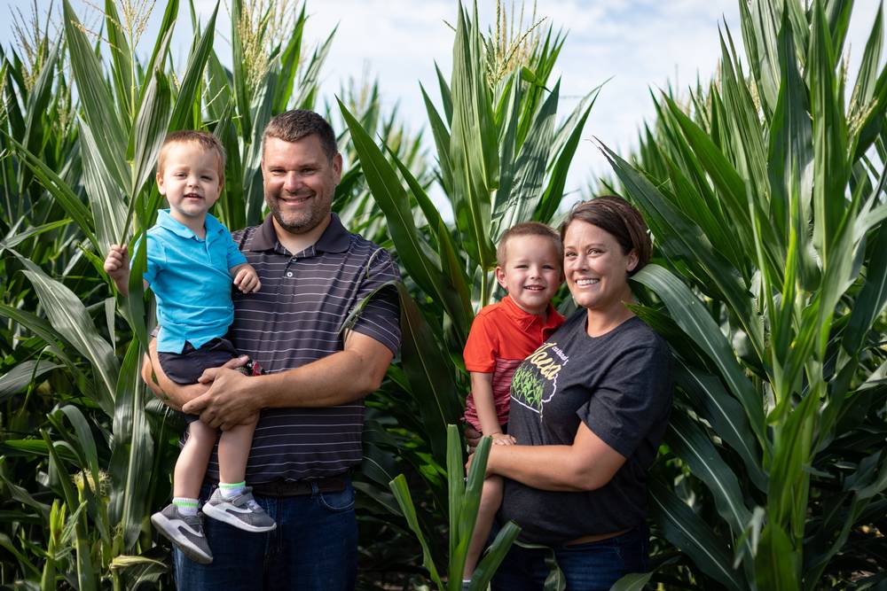Man, woman, and two kids standing in a cornfield