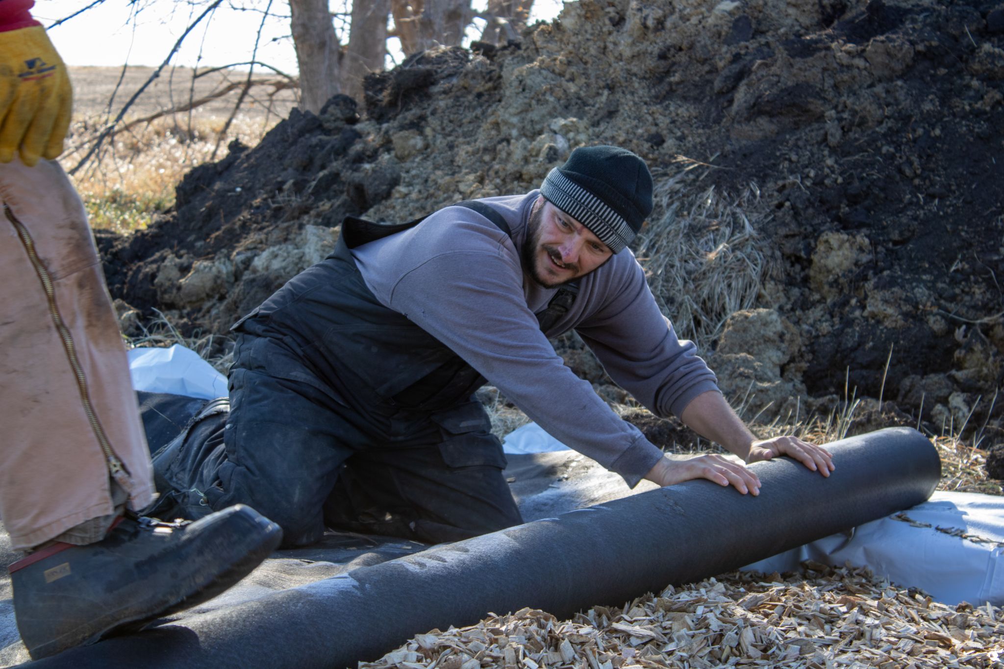 man rolls out material for biroeactor