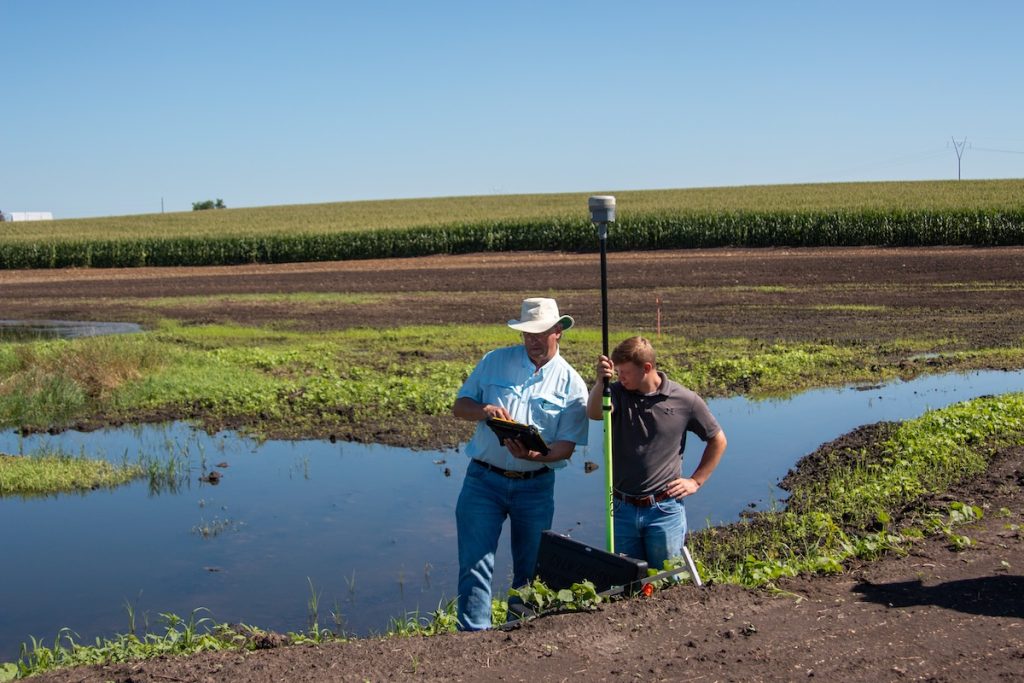 two men in front of wetland