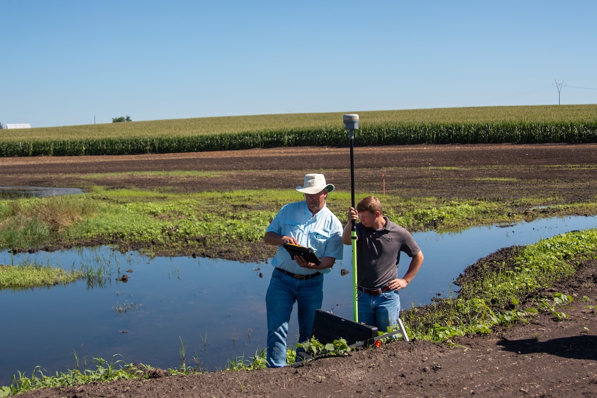 two men in front of wetland