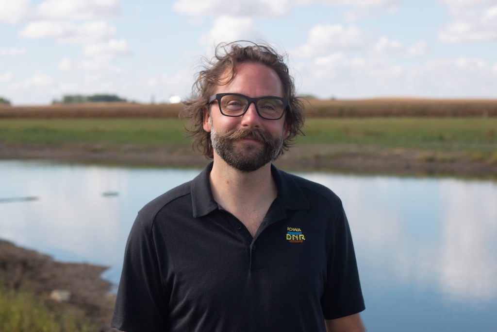 man standing in front of pond