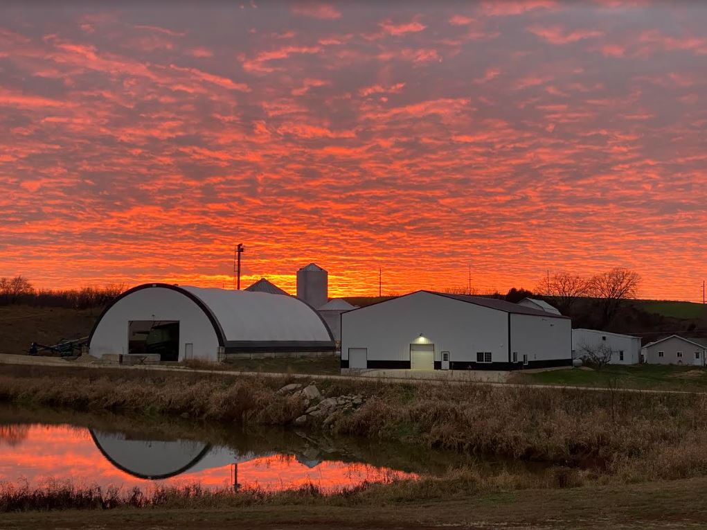 orange sunset over farm buildings