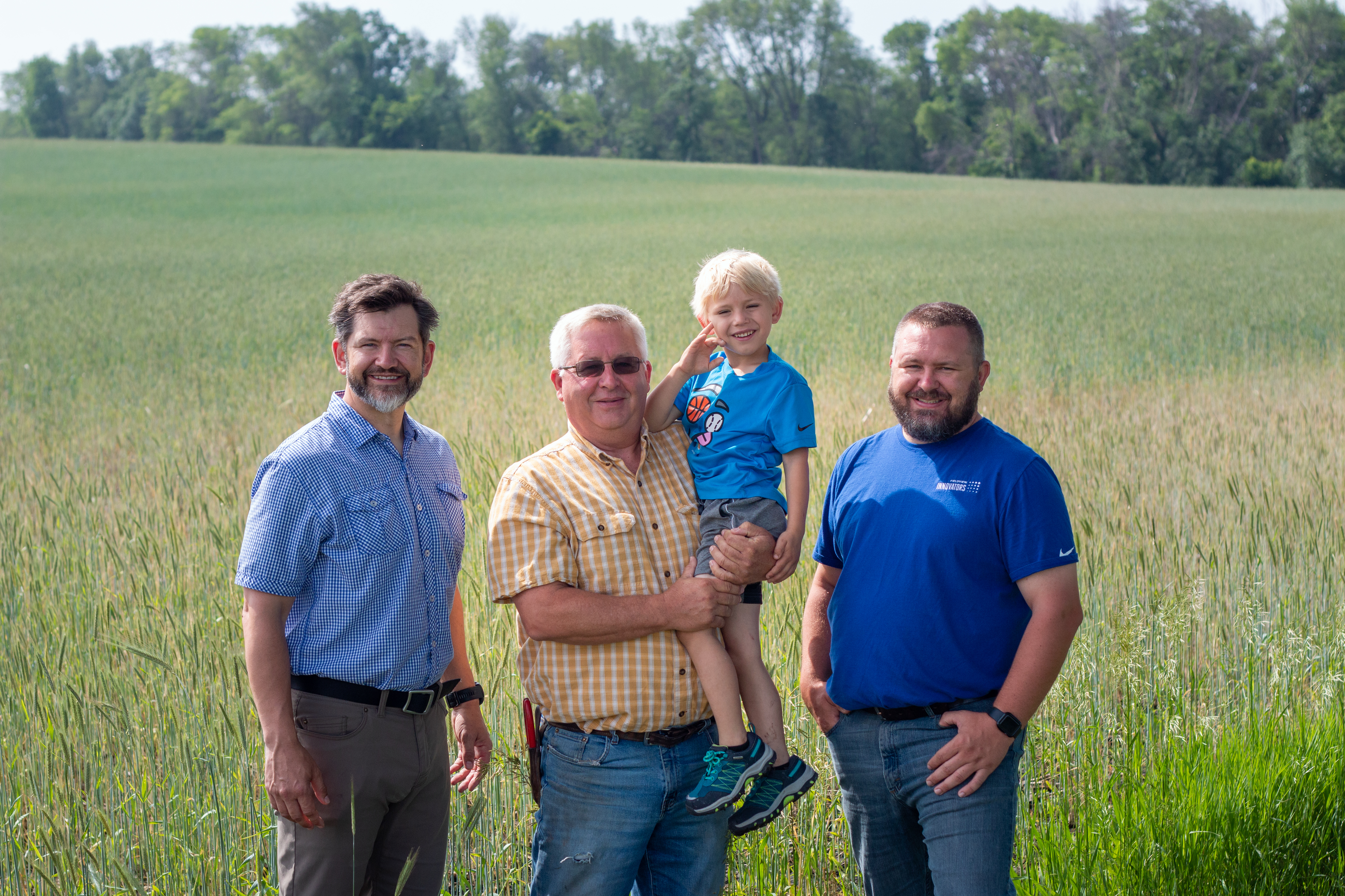 Helland family stands in front of rye field
