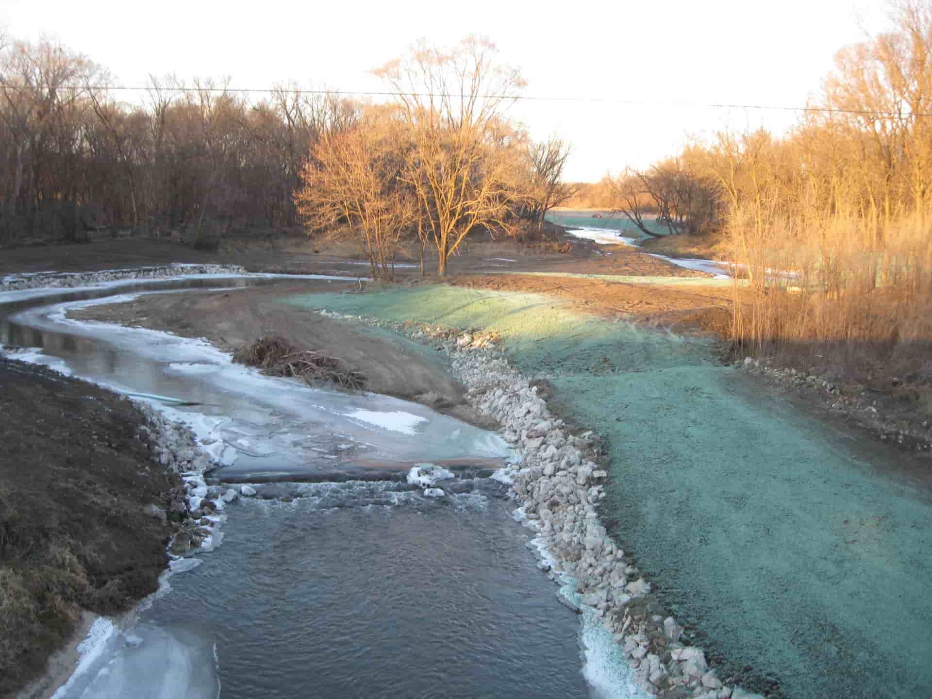 Aerial view of completed stream buffer; rocks lining stream and grass seed planted above on land