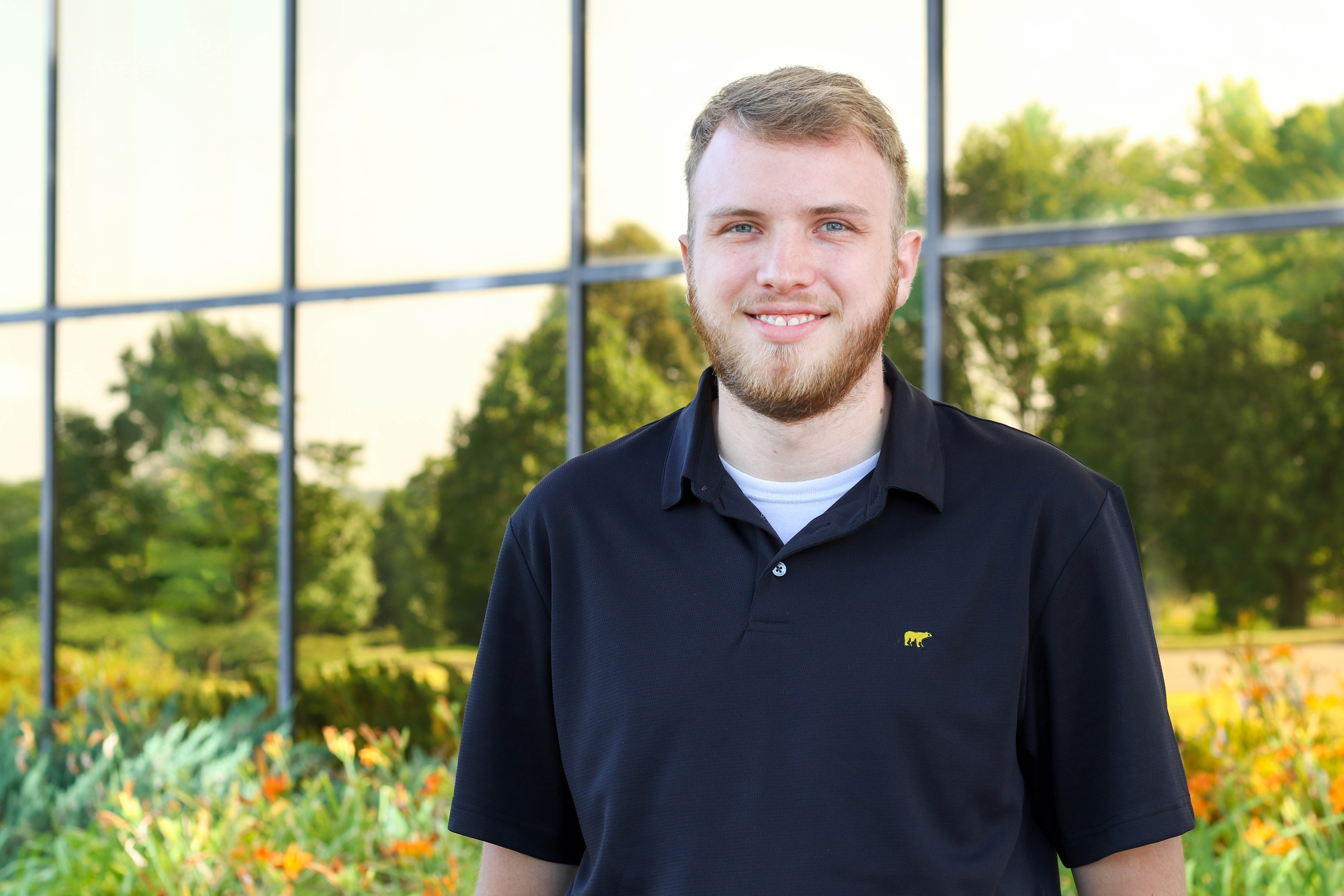 Tanner puls stands in greenhouse