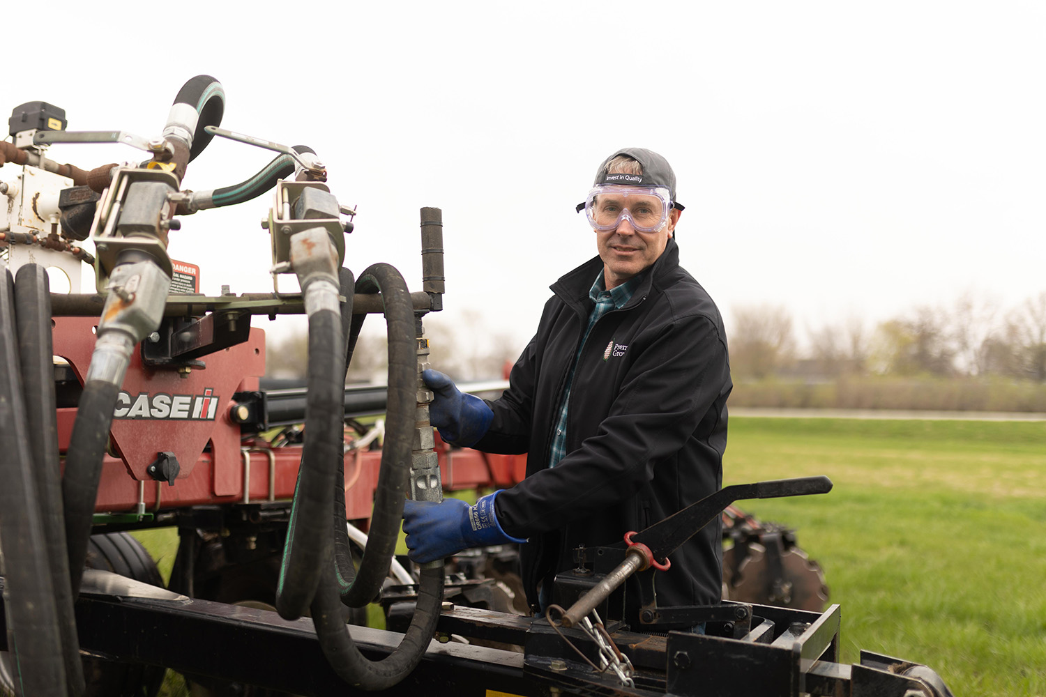 farmer stands next to tractor